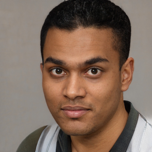 Joyful black young-adult male with short  black hair and brown eyes