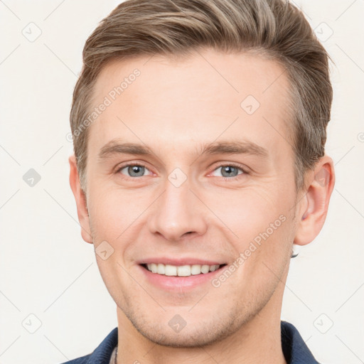 Joyful white young-adult male with short  brown hair and grey eyes