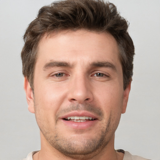 Joyful white young-adult male with short  brown hair and grey eyes