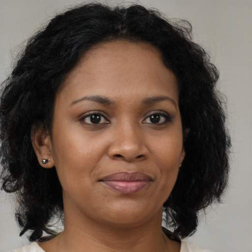 Joyful black young-adult female with medium  brown hair and brown eyes