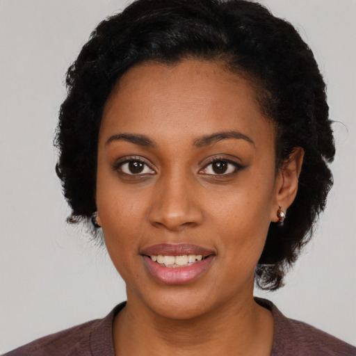 Joyful black young-adult female with medium  black hair and brown eyes
