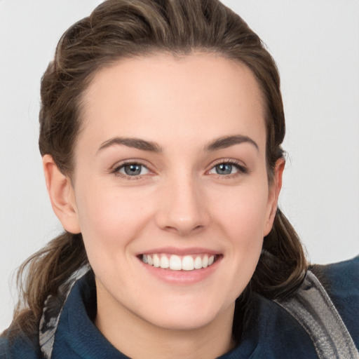 Joyful white young-adult female with medium  brown hair and grey eyes