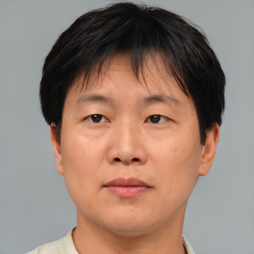 Joyful asian adult male with short  brown hair and brown eyes
