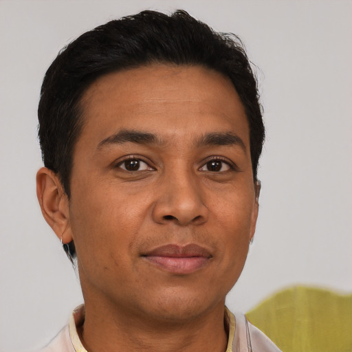 Joyful latino young-adult male with short  brown hair and brown eyes