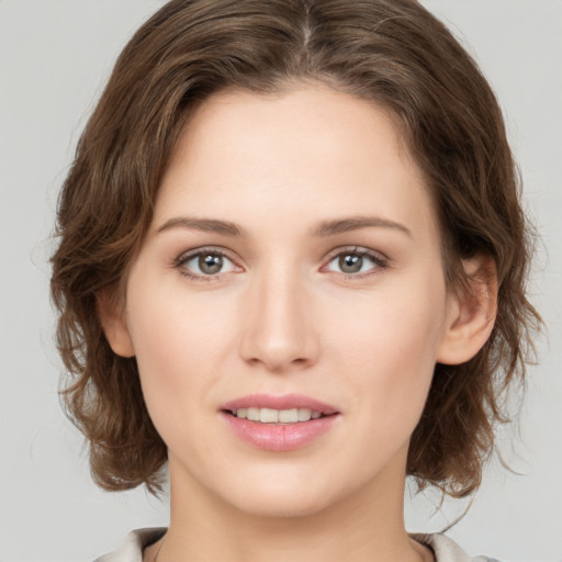 Joyful white young-adult female with medium  brown hair and green eyes