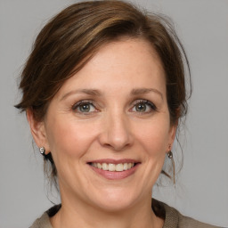 Joyful white adult female with medium  brown hair and grey eyes