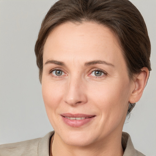 Joyful white adult female with medium  brown hair and grey eyes