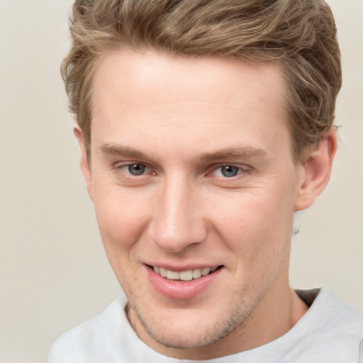 Joyful white young-adult male with short  brown hair and grey eyes