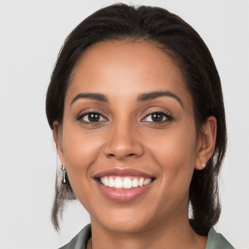 Joyful latino young-adult female with medium  brown hair and brown eyes