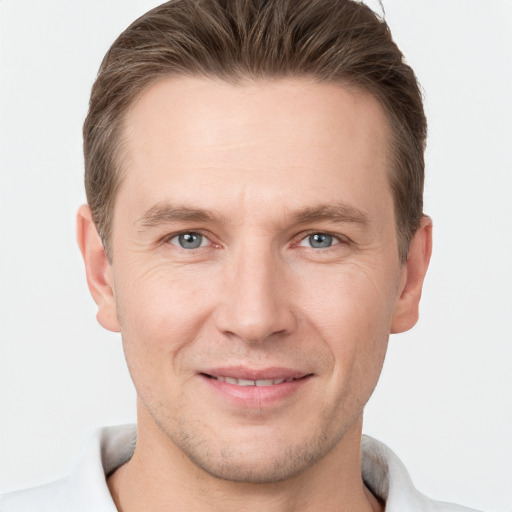 Joyful white young-adult male with short  brown hair and grey eyes