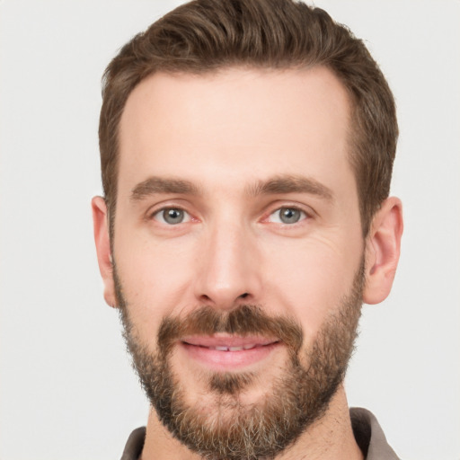 Joyful white young-adult male with short  brown hair and grey eyes