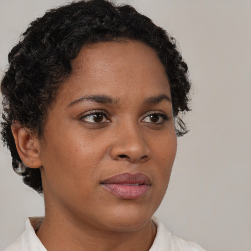 Joyful black young-adult female with short  brown hair and brown eyes