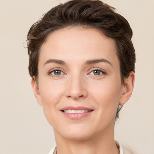 Joyful white young-adult female with short  brown hair and grey eyes