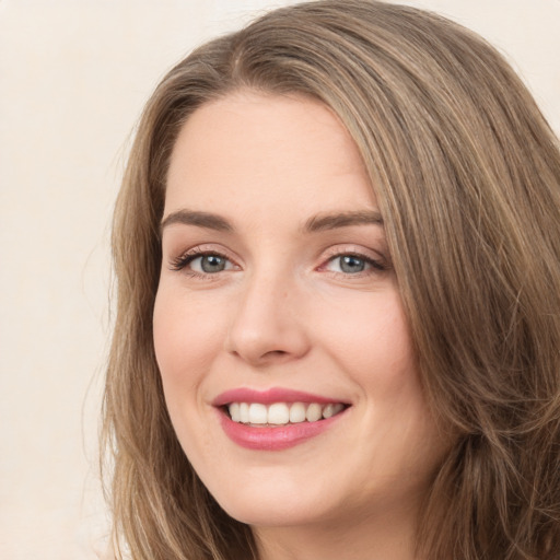 Joyful white young-adult female with long  brown hair and green eyes