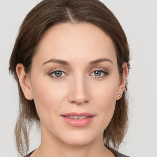 Joyful white young-adult female with long  brown hair and grey eyes