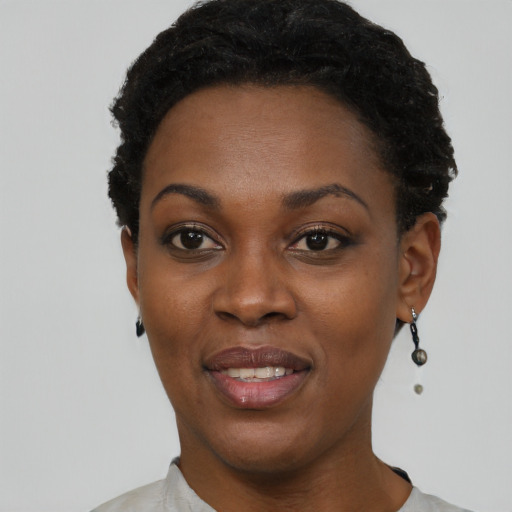 Joyful black young-adult female with short  black hair and brown eyes