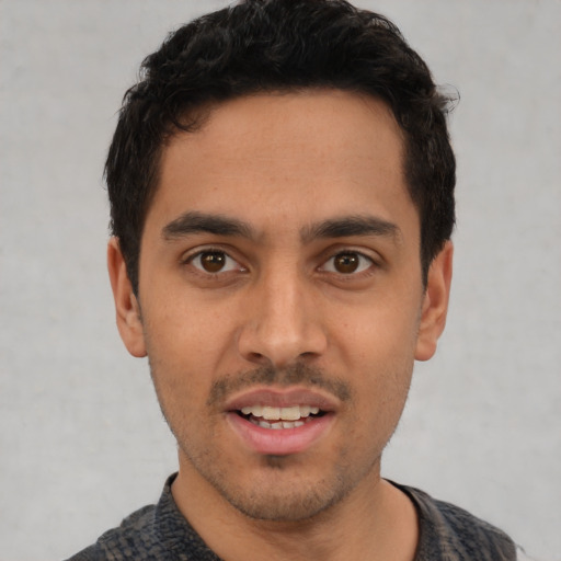 Joyful latino young-adult male with short  black hair and brown eyes