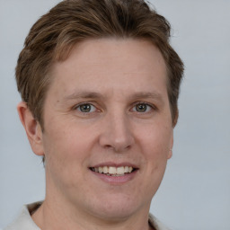 Joyful white adult male with short  brown hair and grey eyes