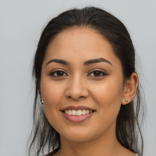 Joyful latino young-adult female with long  brown hair and brown eyes