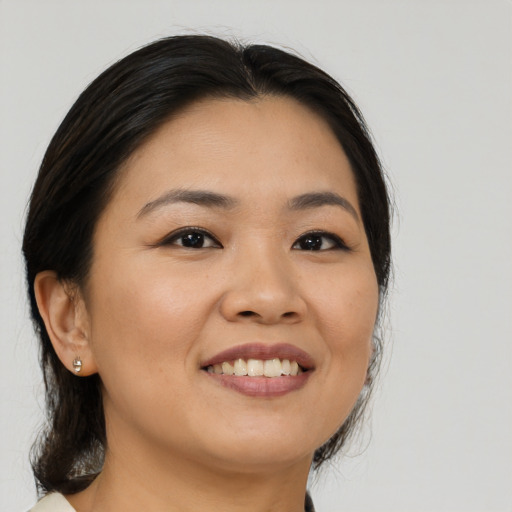 Joyful asian young-adult female with medium  brown hair and brown eyes