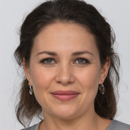 Joyful white adult female with medium  brown hair and grey eyes