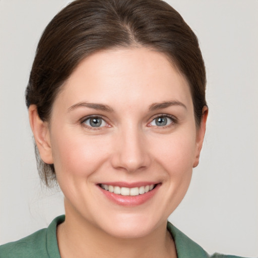 Joyful white young-adult female with medium  brown hair and grey eyes