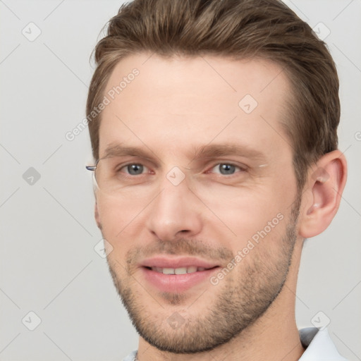 Joyful white young-adult male with short  brown hair and grey eyes