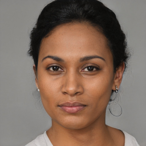 Joyful latino young-adult female with short  black hair and brown eyes