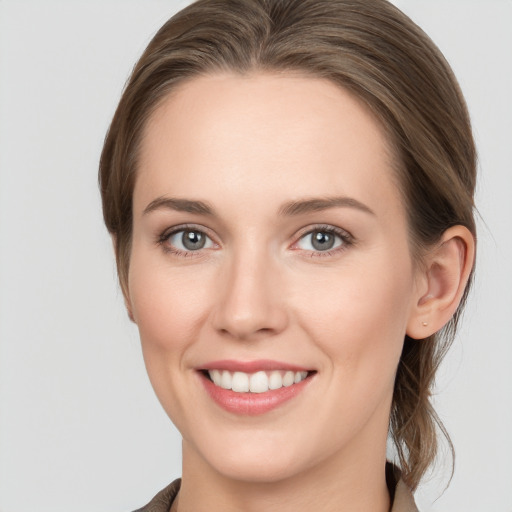 Joyful white young-adult female with medium  brown hair and grey eyes