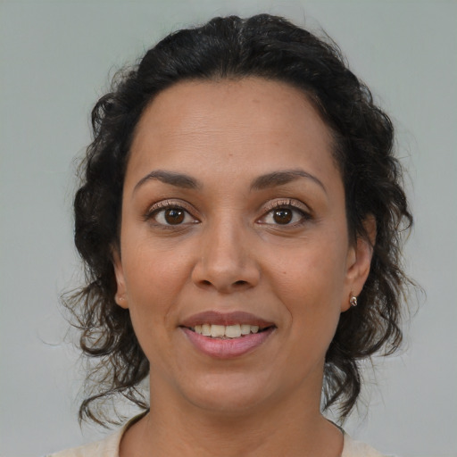 Joyful latino adult female with medium  brown hair and brown eyes