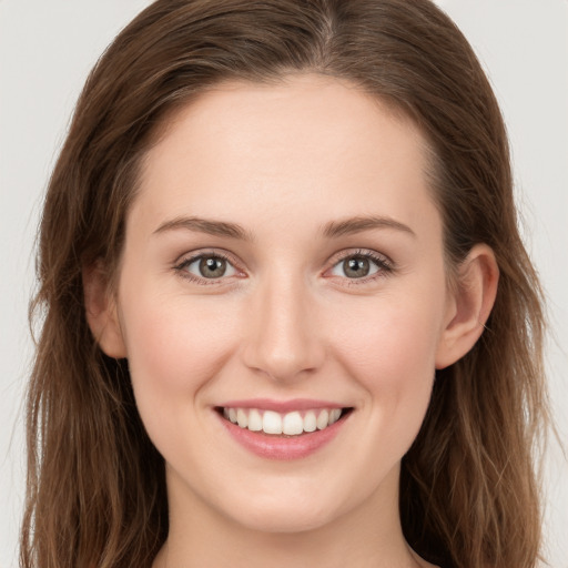 Joyful white young-adult female with long  brown hair and green eyes