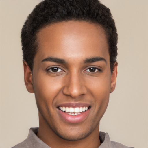 Joyful black young-adult male with short  brown hair and brown eyes