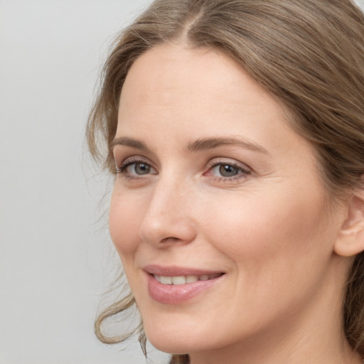 Joyful white young-adult female with long  brown hair and grey eyes