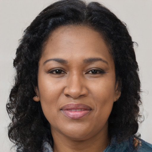 Joyful black adult female with long  black hair and brown eyes