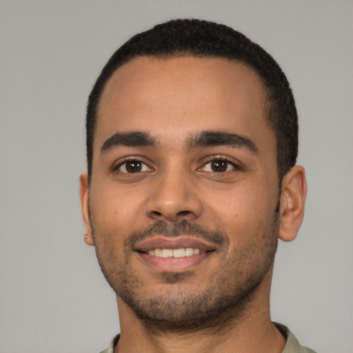 Joyful latino young-adult male with short  black hair and brown eyes