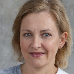 Joyful white adult female with medium  brown hair and blue eyes