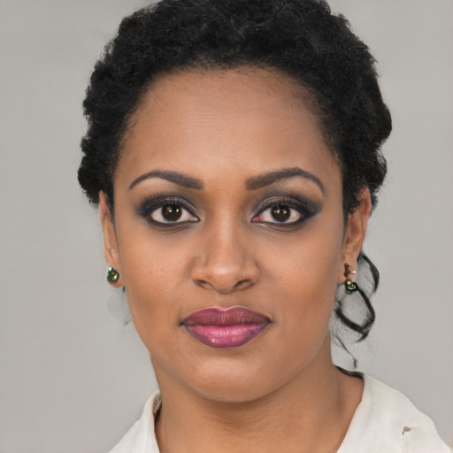 Joyful black young-adult female with short  black hair and brown eyes