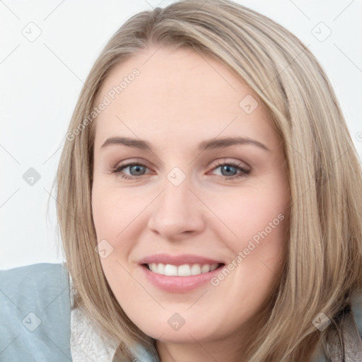 Joyful white young-adult female with long  brown hair and blue eyes