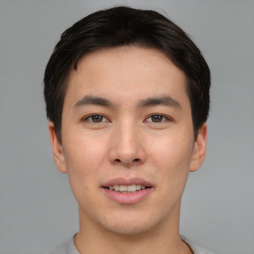 Joyful asian young-adult male with short  brown hair and brown eyes
