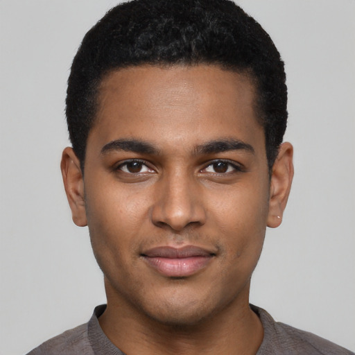 Joyful black young-adult male with short  black hair and brown eyes
