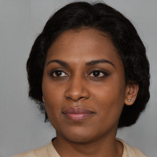 Joyful black young-adult female with medium  brown hair and brown eyes