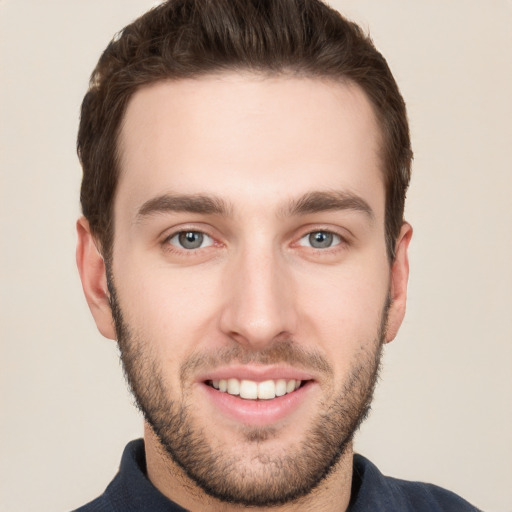 Joyful white young-adult male with short  brown hair and grey eyes