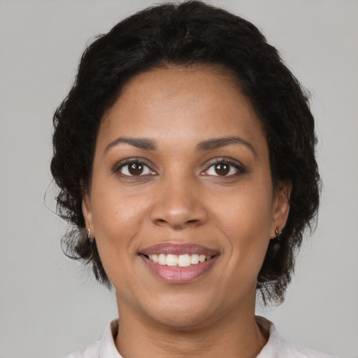 Joyful black young-adult female with short  brown hair and brown eyes