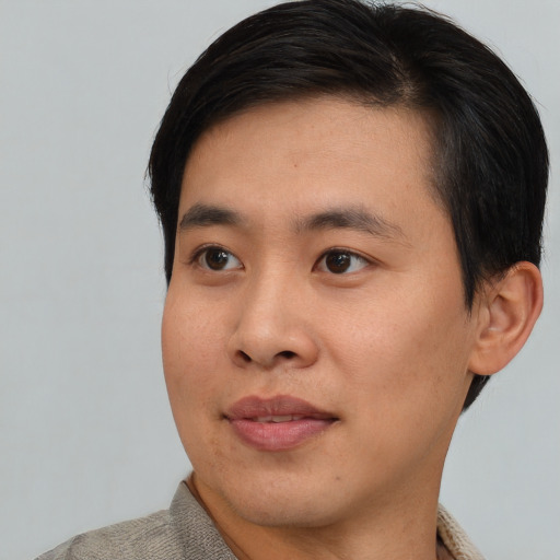 Joyful asian young-adult male with short  black hair and brown eyes