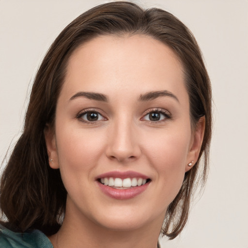 Joyful white young-adult female with long  brown hair and blue eyes