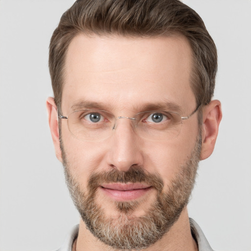 Joyful white adult male with short  brown hair and grey eyes