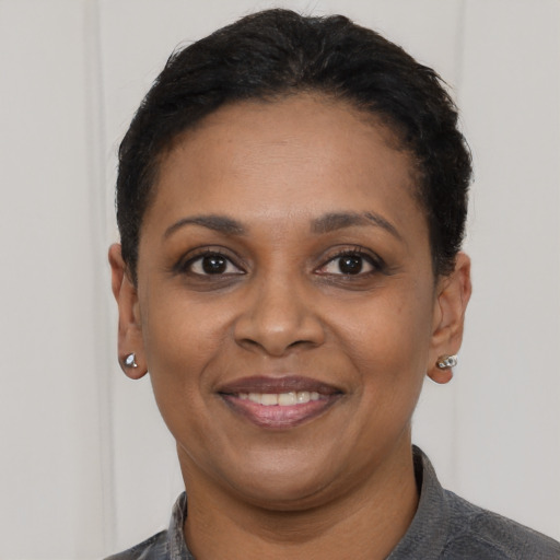 Joyful black young-adult female with short  black hair and brown eyes