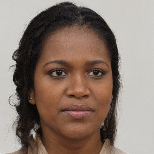 Joyful black young-adult female with long  brown hair and brown eyes