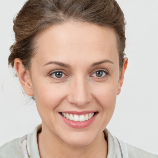 Joyful white young-adult female with short  brown hair and blue eyes