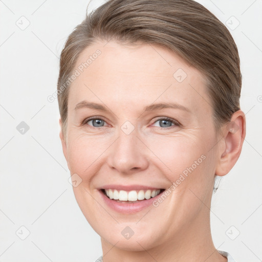 Joyful white young-adult female with short  brown hair and grey eyes